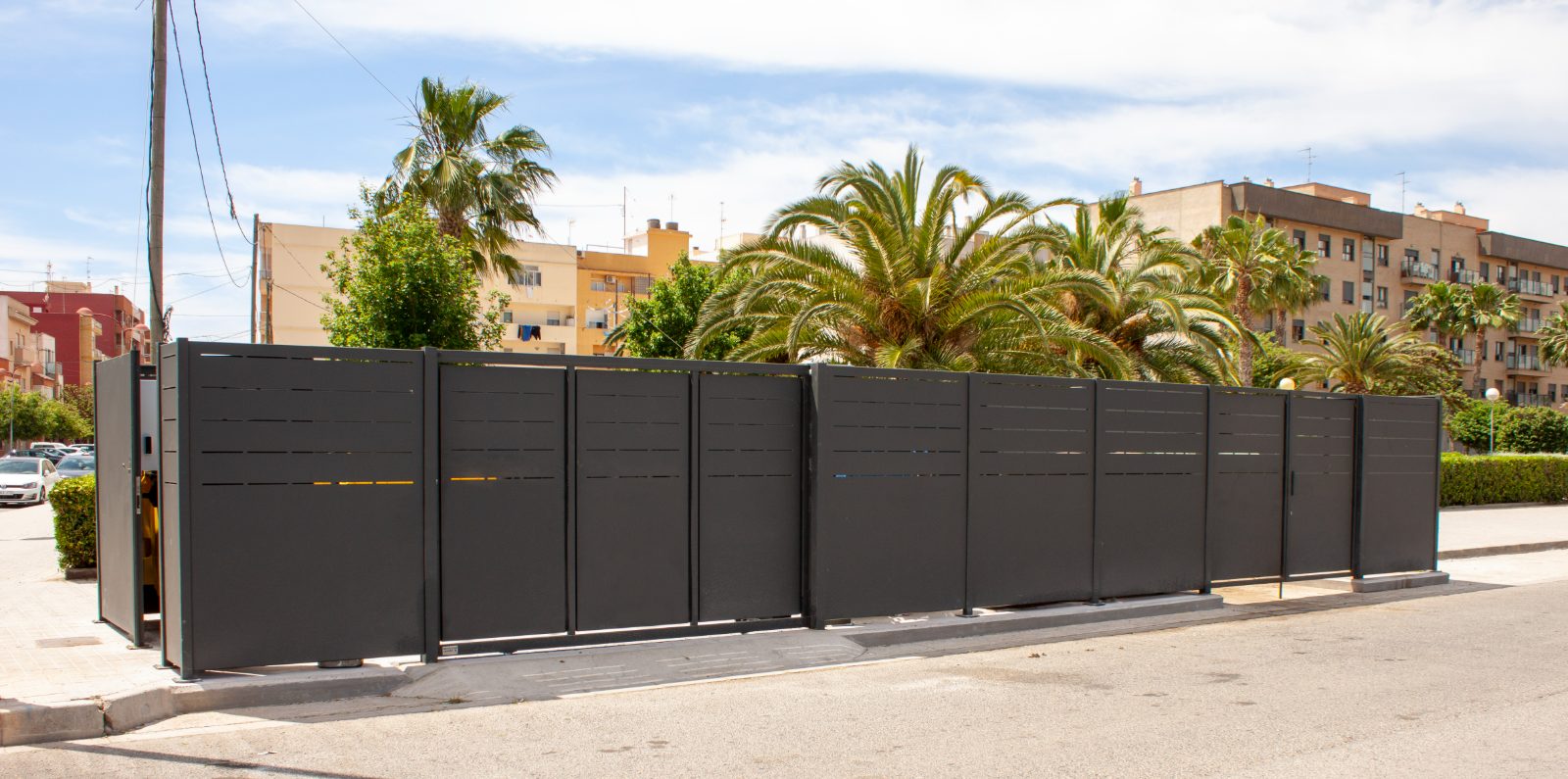Cercamiento metálico modular para área de contenedores, instalado en vía urbana